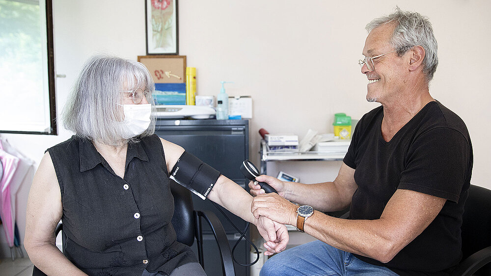 Un médecin prend la tension d'une patiente.