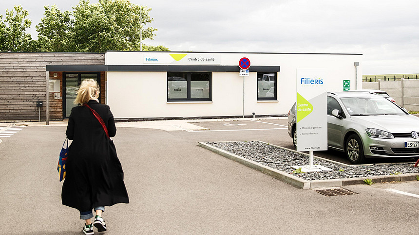 Une patiente avance vers le centre Filieris de Mazingarbe à côté des places de parking