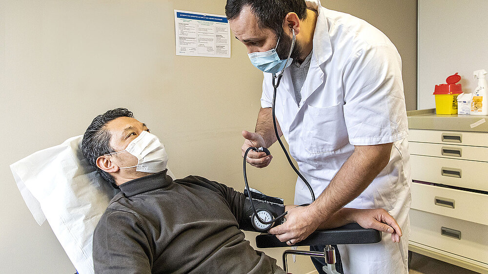 Un infirmier prend la tension d'un patient.