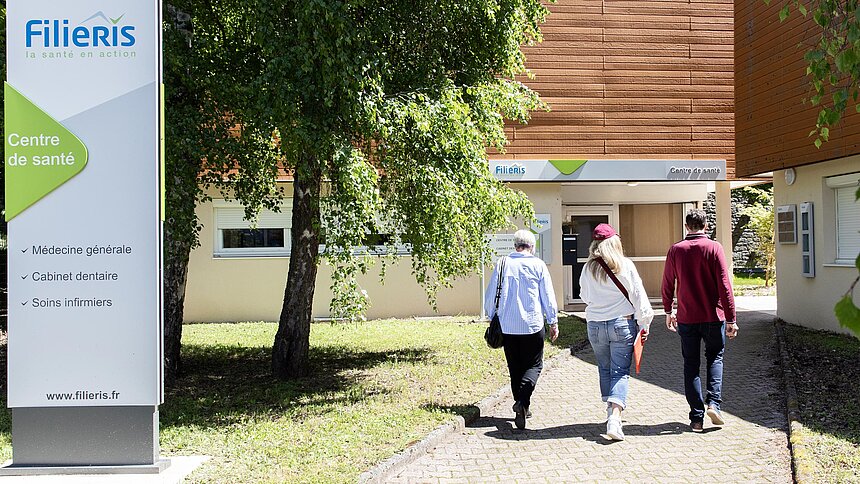 Trois patients entrent dans le centre de santé.