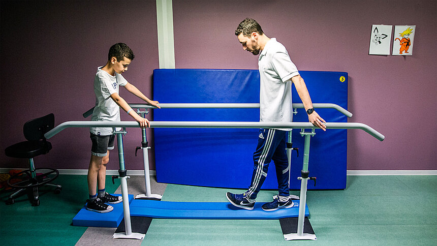 Rééducation d'un jeune garçon sur tapis de marche avec un professionnel Filieris