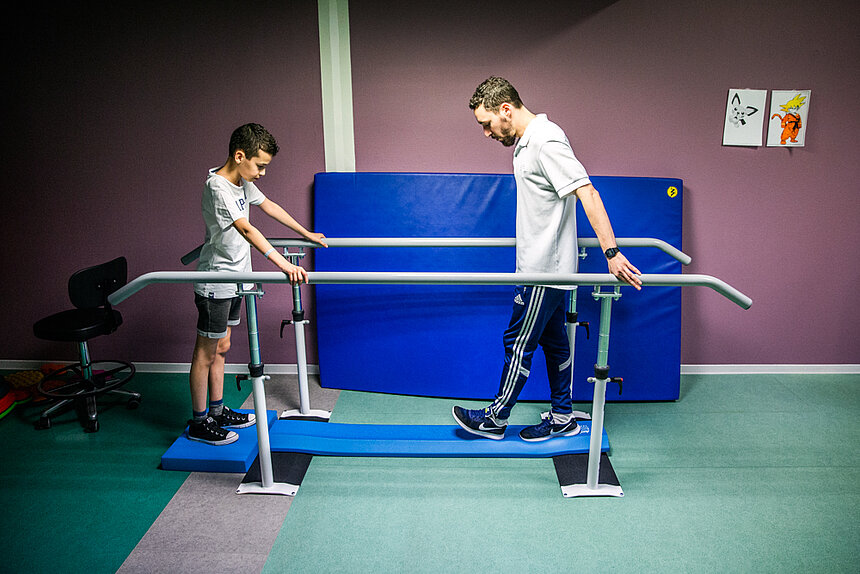 Rééducation d'un jeune garçon sur tapis de marche avec un professionnel Filieris