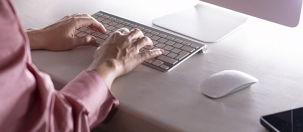 Les mains d'une femme qui tapent sur un clavier d'ordinateur