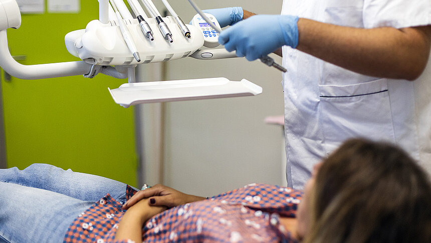 Une patiente est allongée sur le fauteuil du dentiste.