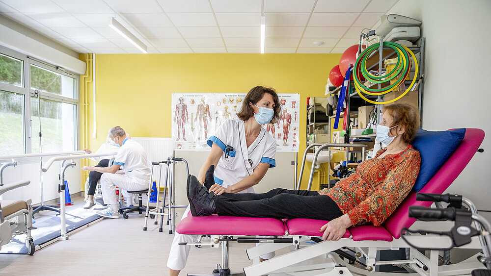 Une patiente et une kinésithérapeute travaillent en salle de réadaptation