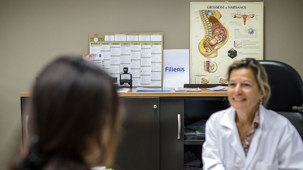 Une patiente discute au cabinet de sa gynécologue.