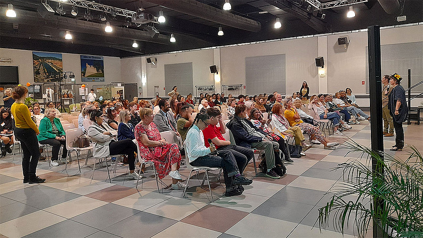 Les participants sont assis devant la scène et les comédiens.