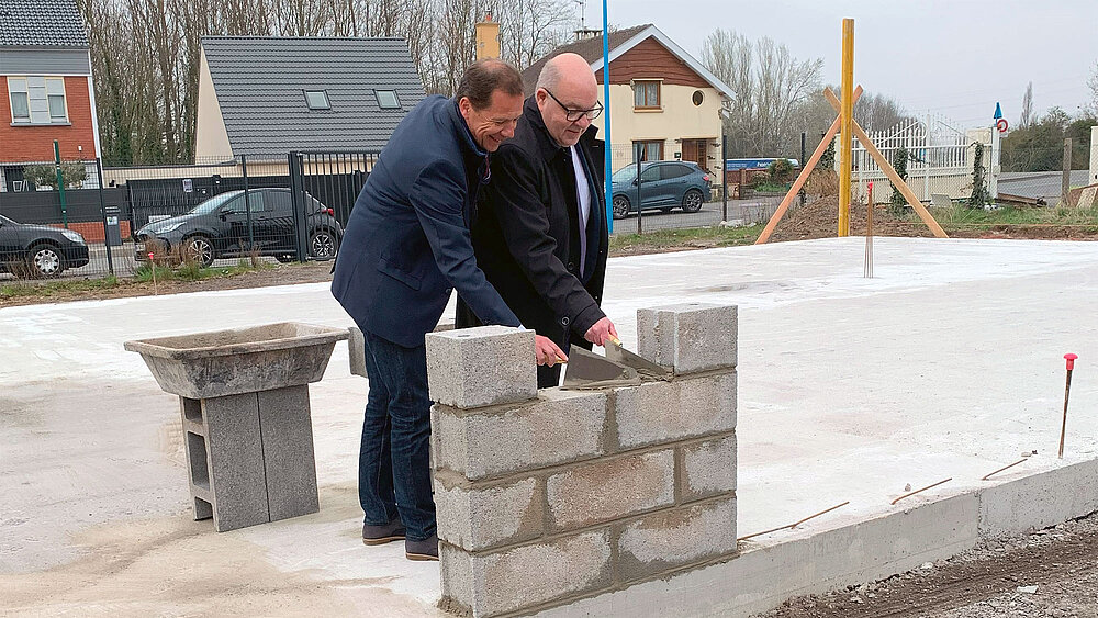 Truelles en main, Nicolas Blanchart et Jean-Michel Dupont montent le premier mur du futur centre de santé.