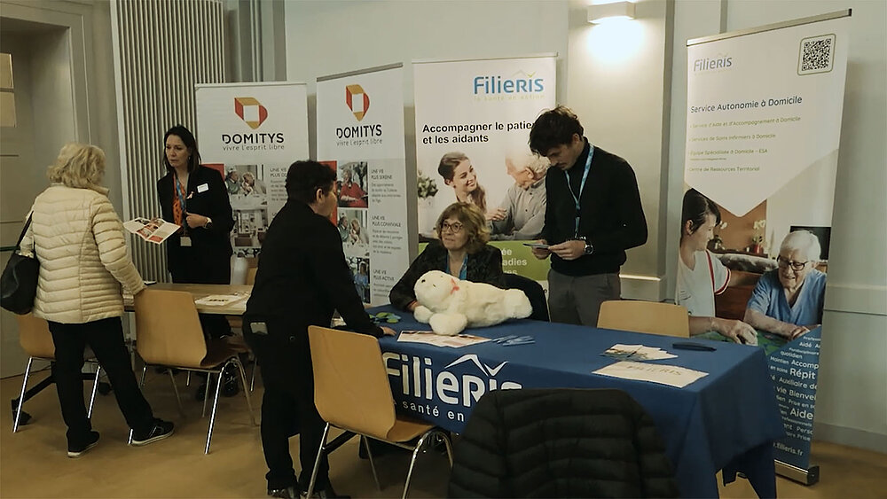 Une personne pose des questions devant le stand Filieris.